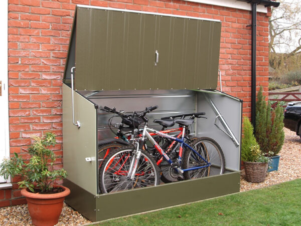 store per biciclette verde con muro in mattoni dietro